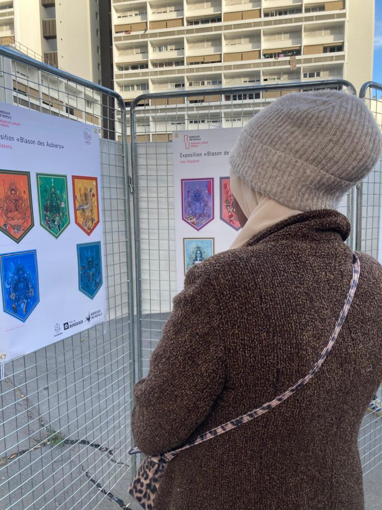 Une apprenante en FLE lit les informations sur l'exposition "Blason les Aubiers"